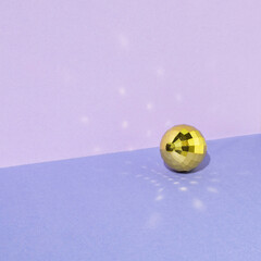 Gold disco balls on a purple background. Creative concept.