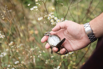 Time concept. New year midnight. Close-up of old gold-plated pocket watch in male hand on natural...