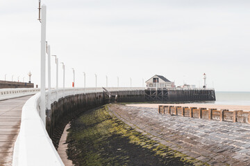 Fototapeta na wymiar Wooden white pier topped with a lighthouse in Blankenberge, coast of Belgium