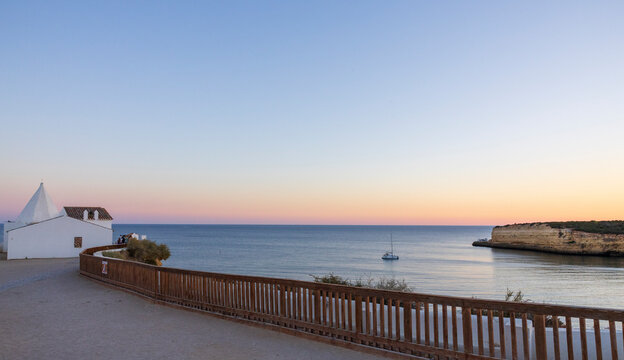 Beautiful sunset on the New Beach (Praia Nova), with the Chapel of Our Lady of the Rock in Porches, Algarve, Portugal