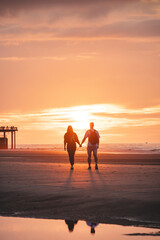 Romantic walk of a young couple on the beaches of Oostende in western Belgium at sunset. Love and...