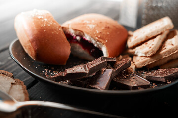 The concept of sweets. Cookies, chocolate and bun on a wooden table. For coffee and tea