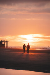 Romantic walk of a young couple on the beaches of Oostende in western Belgium at sunset. Love and...