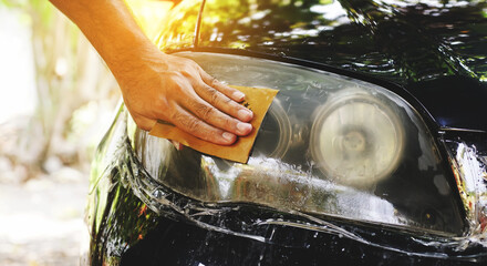 Male hands polishing car headlights, car lamp or front headlight polishing, renewed headlamp,...