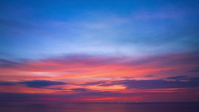.Aerial hyperlapse day to night clouds are moving slowly in the colorful sky during sunset..amazing pink cloud in purple sky in beautiful sunset at the sea..colorful sky sunset or sunrise background.