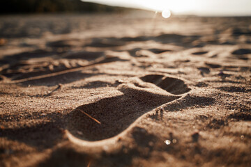 A footprint on the sand by the sea at sunset
