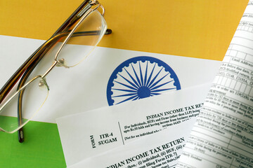 Indian income tax return blank form with pen and indian rupees bills on indian country flag close...