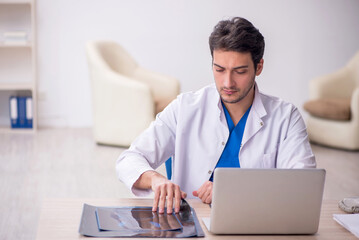 Young doctor radiologist sitting at the hospital