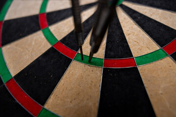 Success hitting target aim goal achievement concept background - three darts in bull's eye close up.