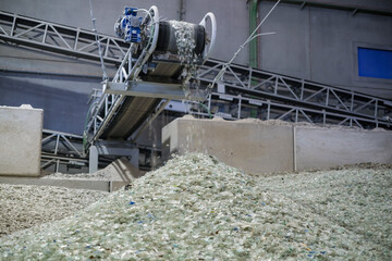 A belt transports crushed glass material ready for recycling
