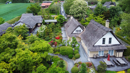 Fototapeta na wymiar Idyllic drone point of view on Japanese garden in Odense district with houses with thatched roofs