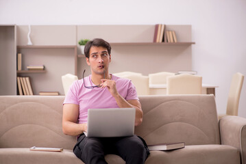 Naklejka premium Young male student preparing for exams at home