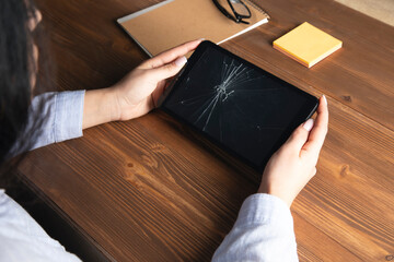 woman holding a broken tablet on her hand
