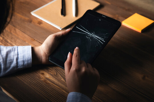 woman holding a broken tablet on her hand