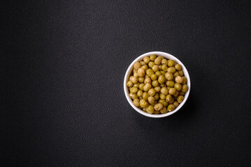 Delicious canned green peas with salt and spices in a white bowl