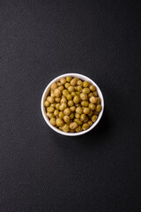 Delicious canned green peas with salt and spices in a white bowl