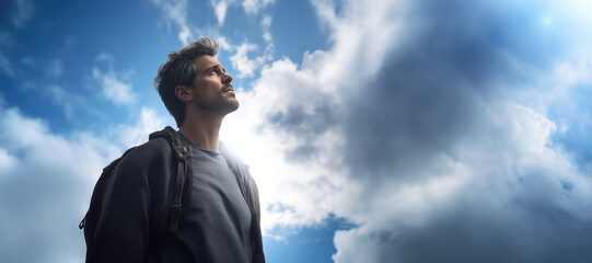 Portrait of a man with backpack looking at blue sky with clouds - obrazy, fototapety, plakaty