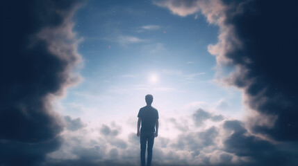 Silhouette of a man in front of the sky with clouds and sunlight
