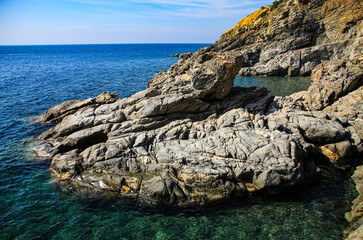 Stony rocky shore of the sea, on a sunny summer day. A beautiful view of the rocks and the sea of...