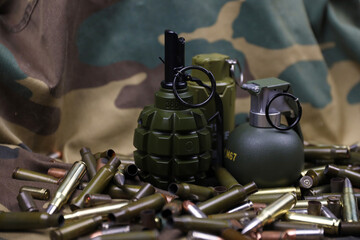 Different types of ammunition and grenades on a camouflage background. Preparing for war....