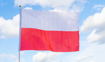 Fototapeta na wymiar Polish flag against a blue sky. Poland European country.