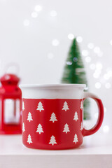 close up large red cup with pattern of white Christmas trees on table. celebration, winter holiday