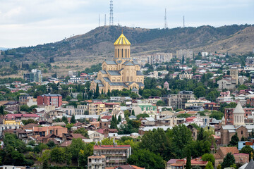 Fototapeta na wymiar The Kura river, The Bridge of Peace, The Holy Trinity Cathedral of Tbilisi, churches and the magnificent view of Tbilisi city from the cable car.