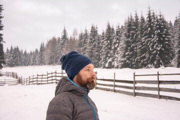 Fototapeta na wymiar man with a beard in freezing cold in the winter freezes