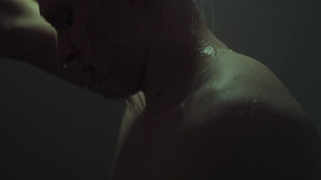 A relaxed man enjoys hot morning shower, feeling the warm water caress his skin. The bathroom of city apartment is filled with calm, washing away the negativity that has accumulated over the past day
