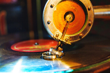 Wedding rings on gramophone needle and record. 