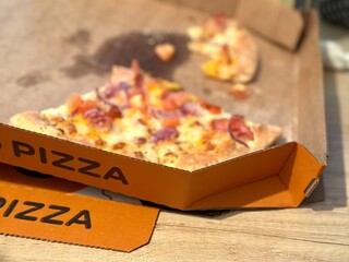 A slice of pizza in a paper box,