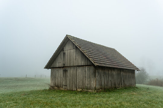 Old barn in a foggy field