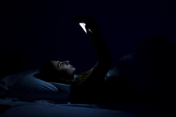 beautiful young girl in bed with white bed and phone