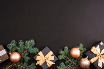 Golden Christmas balls, gifts and decorations on black background. Festive flat lay. Top view, copy...