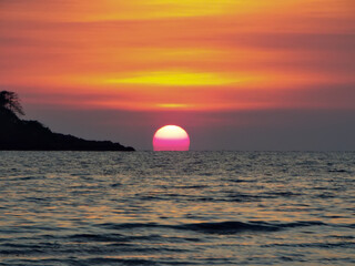 Scenery. The orange sunset sun falls into the water. Nature and beauty concept. Thailand