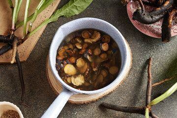 Fresh sliced comfrey root macerating in rendered pork lard - preparation of ointment for bones