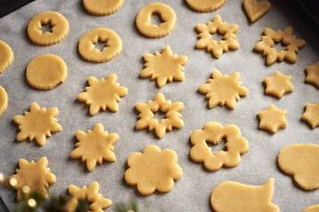 Shapes made of pastry dough on baking paper - preparation of Linzer Christmas cookies