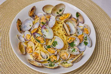 Plate with the Italian dish Spaghetti Alle Vongole on the table.