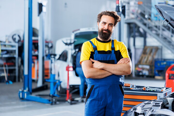 Portrait of happy serviceman in auto repair shop tasked with changing cars oil. Experienced specialist in garage ready to start doing checkups on vehicles in garage workspace