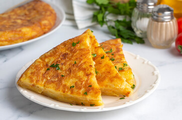 Spanish omelette with potatoes, typical spanish cuisine on gray concrete floor. Tortilla Espanola. Turkish name; Yumurtali patates