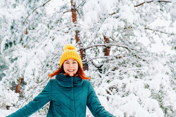 Young smiling woman enjoys snowy winter day. High quality photo