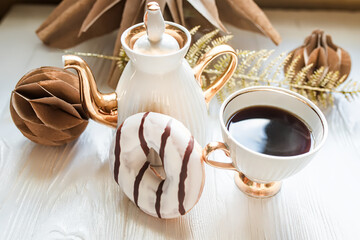 Cup of coffee and chocolate donut on white wooden background. Handmade Kraft Paper Christmas...