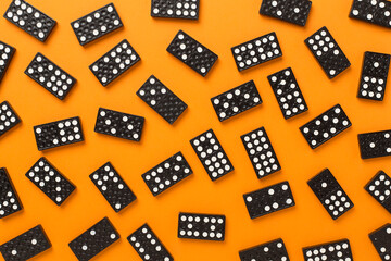 Black domino tiles on color background, top view
