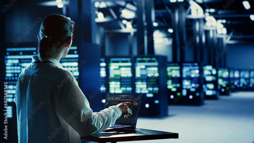 Poster asian system administrator running code and programming on laptop, troubleshooting and upgrading ser