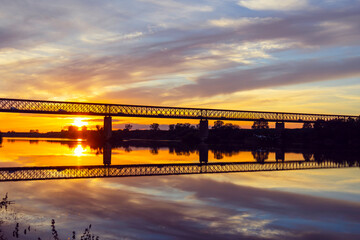Old steel bridge at sunset. Bridge over the Tagus river, in the portuguese village of Chamusca - Ribatejo - Portugal. Bridge Isidro dos Reis - Chamusca