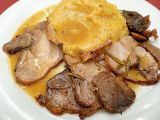 slices of loin meat with polenta and sauce. typical dish from northern Italy