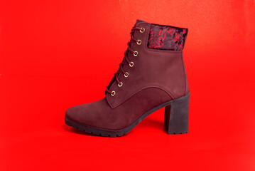 women's cherry ankle boots on red background.