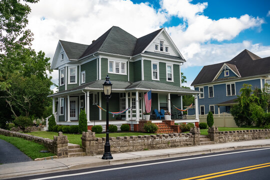 classic American house colonial style. Veranda with columns and flag at entrance.