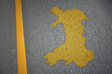 yellow map of wales country on asphalt road near yellow line.