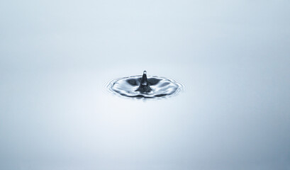 Blue water circles surface with rings and ripples from drop splash